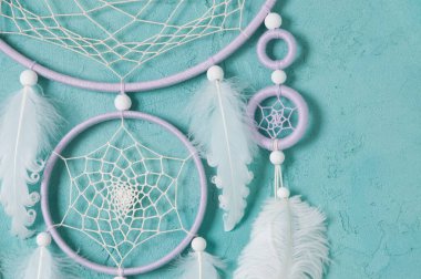 Aquamarine arka planında leylak kremi beyaz rüya yakalayıcısı. Metin için alanı kopyala.