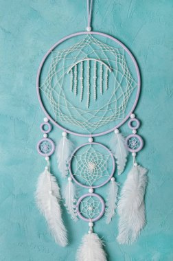 Aquamarine arka planında leylak kremi beyaz rüya yakalayıcısı. Metin için alanı kopyala.