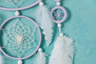 Aquamarine arka planında leylak kremi beyaz rüya yakalayıcısı. Metin için alanı kopyala.