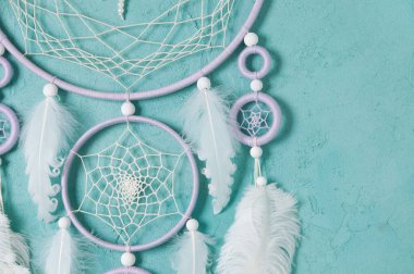 Aquamarine arka planında leylak kremi beyaz rüya yakalayıcısı. Metin için alanı kopyala.