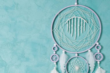 Aquamarine arka planında leylak kremi beyaz rüya yakalayıcısı. Metin için alanı kopyala.