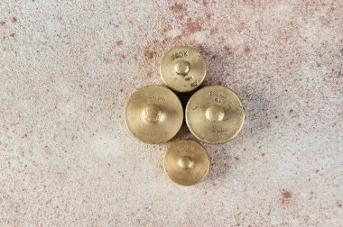 Beton arka plandaki pullar için antika bronz ağırlıklar. Metin ve yemek fotoğrafçılığı için alanı kopyala.