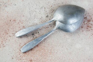 Beton arka planda kocaman alüminyum kaşıklar. Metin ve yemek fotoğrafçılığı için boşluk kopyala.