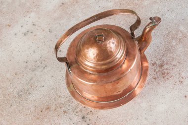 Beton zeminde eski bakır çaydanlık. Metin ve yemek fotoğrafçılığı için boşluk kopyala.