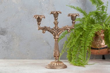 Beton zeminde üç mum için antika pirinç şamdan. Metin için alanı kopyala. 