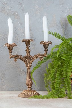 Beton zeminde üç mum için antika pirinç şamdan. Metin için alanı kopyala. 
