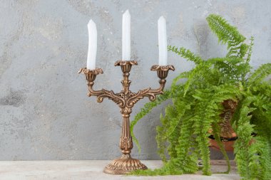 Beton zeminde üç mum için antika pirinç şamdan. Metin için alanı kopyala. 