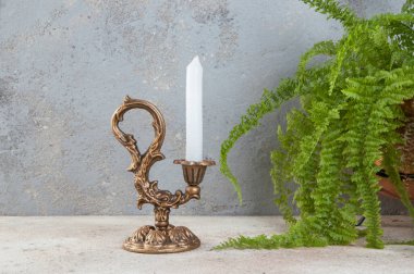 Beton zeminde bir mum için antik pirinç şamdan. Metin için alanı kopyala. 