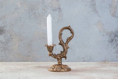 Beton zeminde bir mum için antik pirinç şamdan. Metin için alanı kopyala. 