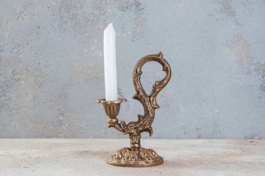 Beton zeminde bir mum için antik pirinç şamdan. Metin için alanı kopyala. 