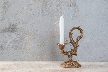 Beton zeminde bir mum için antik pirinç şamdan. Metin için alanı kopyala. 