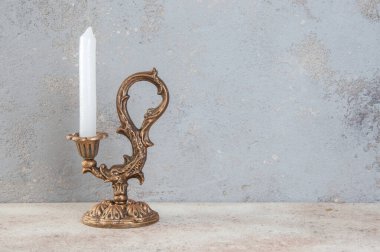 Beton zeminde bir mum için antik pirinç şamdan. Metin için alanı kopyala. 