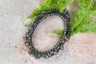 Beton zemin üzerinde antik bronz çerçeve. Metin için fotoğraf desteği ve kopyalama alanı.  