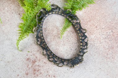 Beton zemin üzerinde antik bronz çerçeve. Metin için fotoğraf desteği ve kopyalama alanı.  