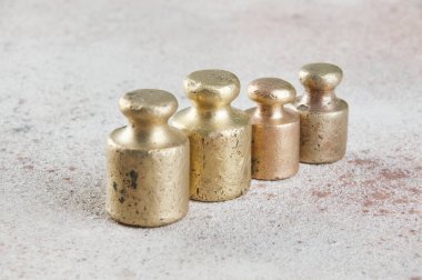 Beton arka planda pullar için dört antika bronz ağırlık. Metin ve yemek fotoğrafçılığı için alanı kopyala.