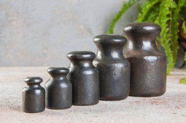 Beton zemindeki pullar için beş antika demir ağırlık. Metin ve yemek fotoğrafçılığı için alanı kopyala.