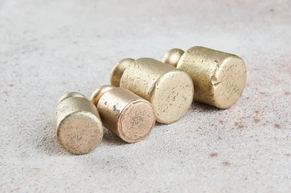 Four antique bronze weights for scales on concrete background. Copy space for text and food photography props.