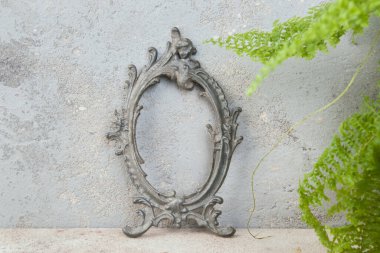 Beton zemin üzerinde antik alüminyum boş resim çerçevesi. Metin için fotoğraf desteği ve kopyalama alanı.  