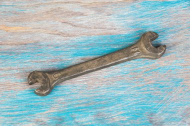 Eski mavi ahşap arka planda klasik bronz ingiliz anahtarı. Metin için alanı kopyala.