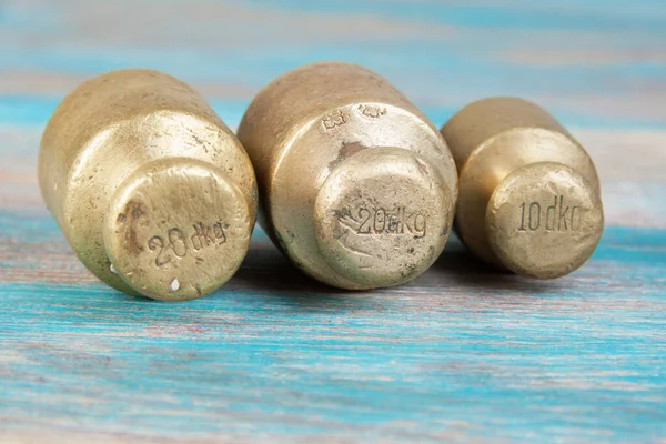 Três Pesos Bronze Antigos Para Escalas Fundo Madeira Azul Espaço — Fotografia de Stock