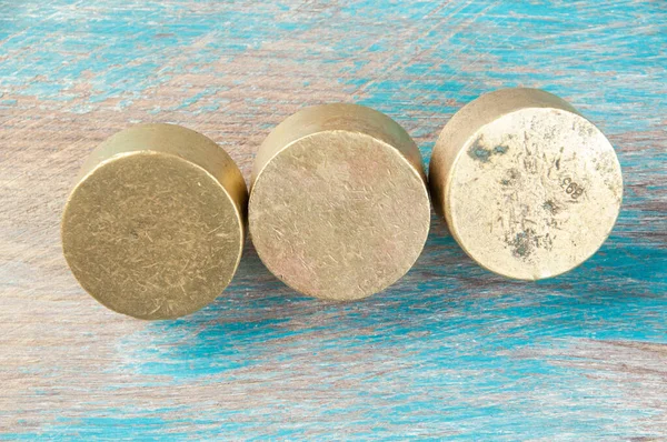 Três Pesos Bronze Antigos Para Escalas Fundo Madeira Azul Espaço — Fotografia de Stock
