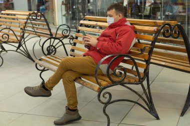 Bir bankta telefonu olan mutlu adam, Coronavirus.