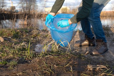 Bir gönüllü boş plastik şişeler topluyor. Ekoloji ve çevre koruma kavramı.
