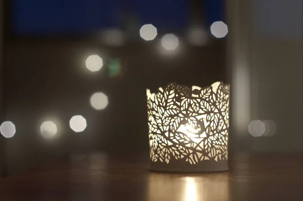 Arkaplanda Bokeh olan oyulmuş beyaz tealight tutucu