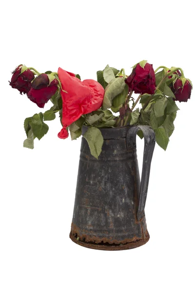 Dried rose bouquet in a rusty jug with deflated balloon on white — Stock Photo, Image