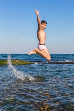 çıplak genç adam sevinç için atlama bakınız su