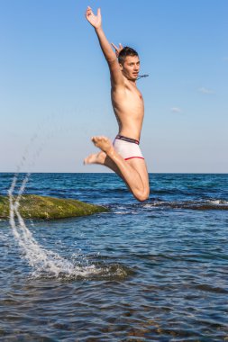 çıplak genç adam sevinç için atlama bakınız su