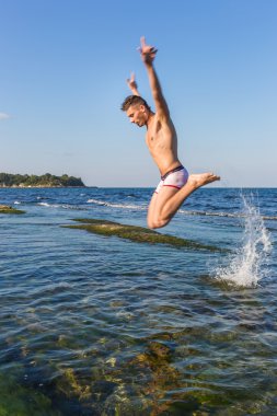 çıplak genç adam sevinç için atlama bakınız su