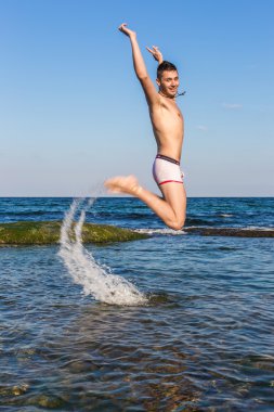 çıplak genç adam sevinç için atlama bakınız su