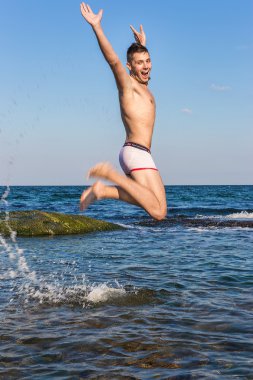 çıplak genç adam sevinç için atlama bakınız su
