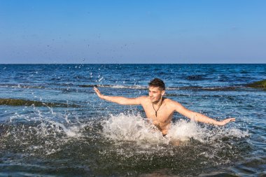 çıplak genç adam sevinç için atlama bakınız su