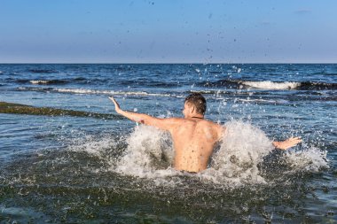 çıplak genç adam sevinç için atlama bakınız su