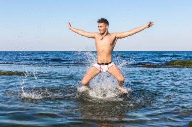 çıplak genç adam sevinç için atlama bakınız su