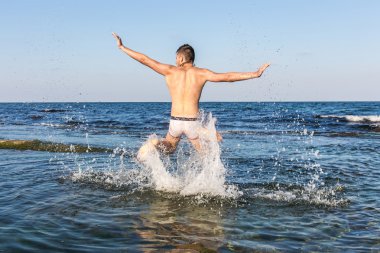 çıplak genç adam sevinç için atlama bakınız su