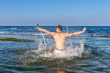 çıplak genç adam sevinç için atlama bakınız su