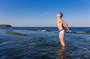 Denizden çıkan çıplak genç adam