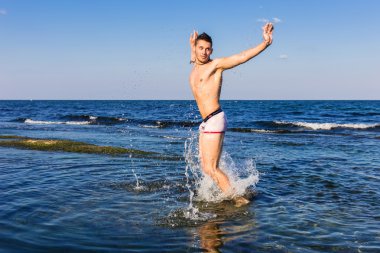 çıplak genç adam sevinç için atlama bakınız su
