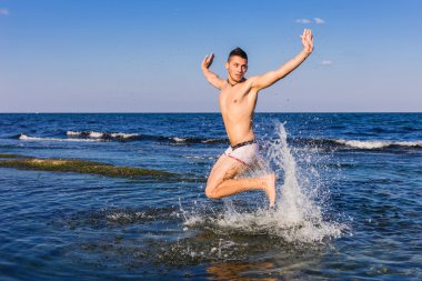 çıplak genç adam sevinç için atlama bakınız su