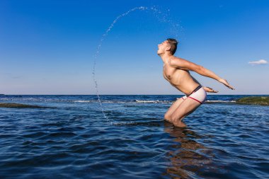 Denizden çıkan çıplak genç adam