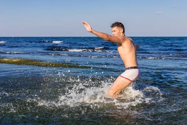 çıplak genç adam sevinç için atlama bakınız su