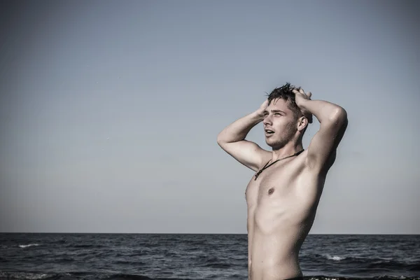 Jovem atraente no mar saindo da água com ha molhada — Fotografia de Stock