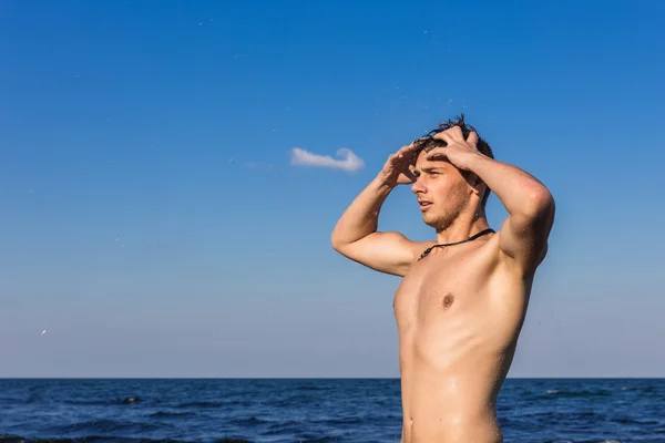 Çekici genç adam denizin ha dışarı su ıslak ile Başlarken