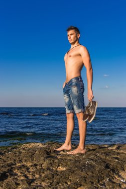 çekici seksi çıplak yakışıklı genç deniz kenarında kayada wa