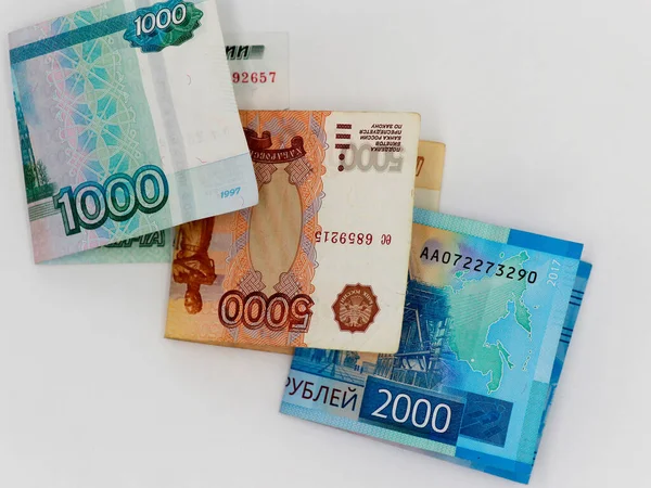 Beyaz arka planda 1000, 2000 ve 5000 ruble 'lik banknotlar halinde katlanmış. Yukarıdan manzara. Rus kağıt parası
