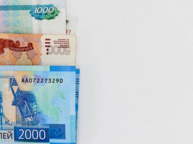 Beyaz arka planda 1000, 2000 ve 5000 ruble 'lik banknotlar halinde katlanmış. Yukarıdan manzara. Rus kağıt parası. Kopyalamak için boş alan