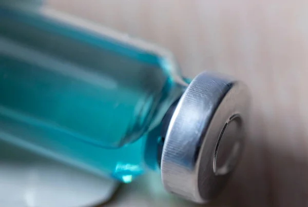 Macro photography of a medical bottle with a vaccine. Selective focus. The concept of vaccination in healthcare, the covid-19 coronavirus vaccine